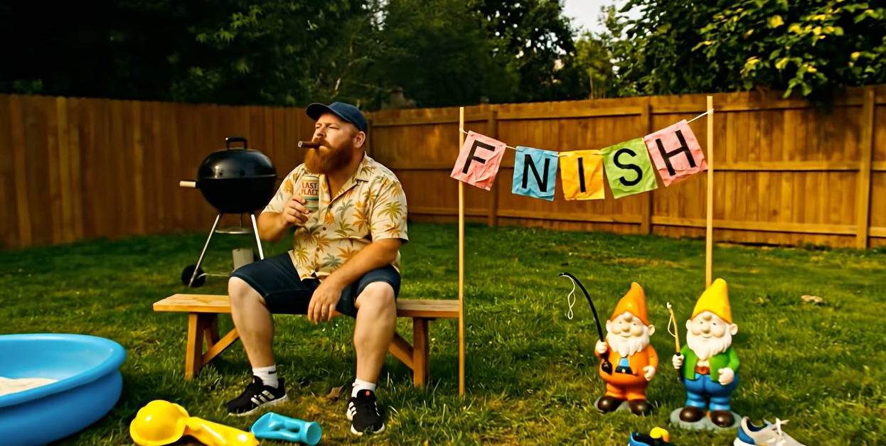 Man sitting on a bench with a barbecue grill, surrounded by garden tools and colorful 'FINISH' sign.